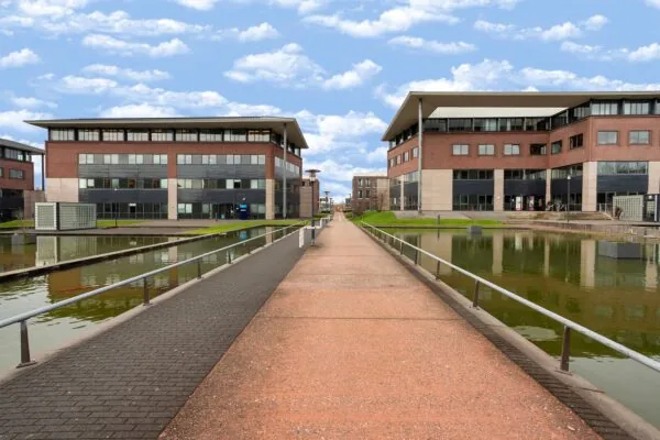 Moderne kantoorgebouwen aan de Boris Pasternaklaan met een voetgangerspad over het water.